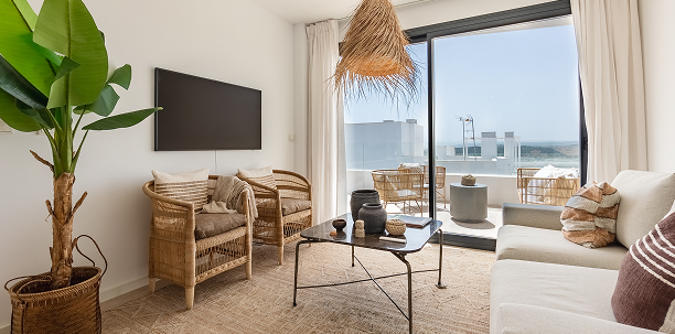 A stylish living room with a large window view of the ocean.