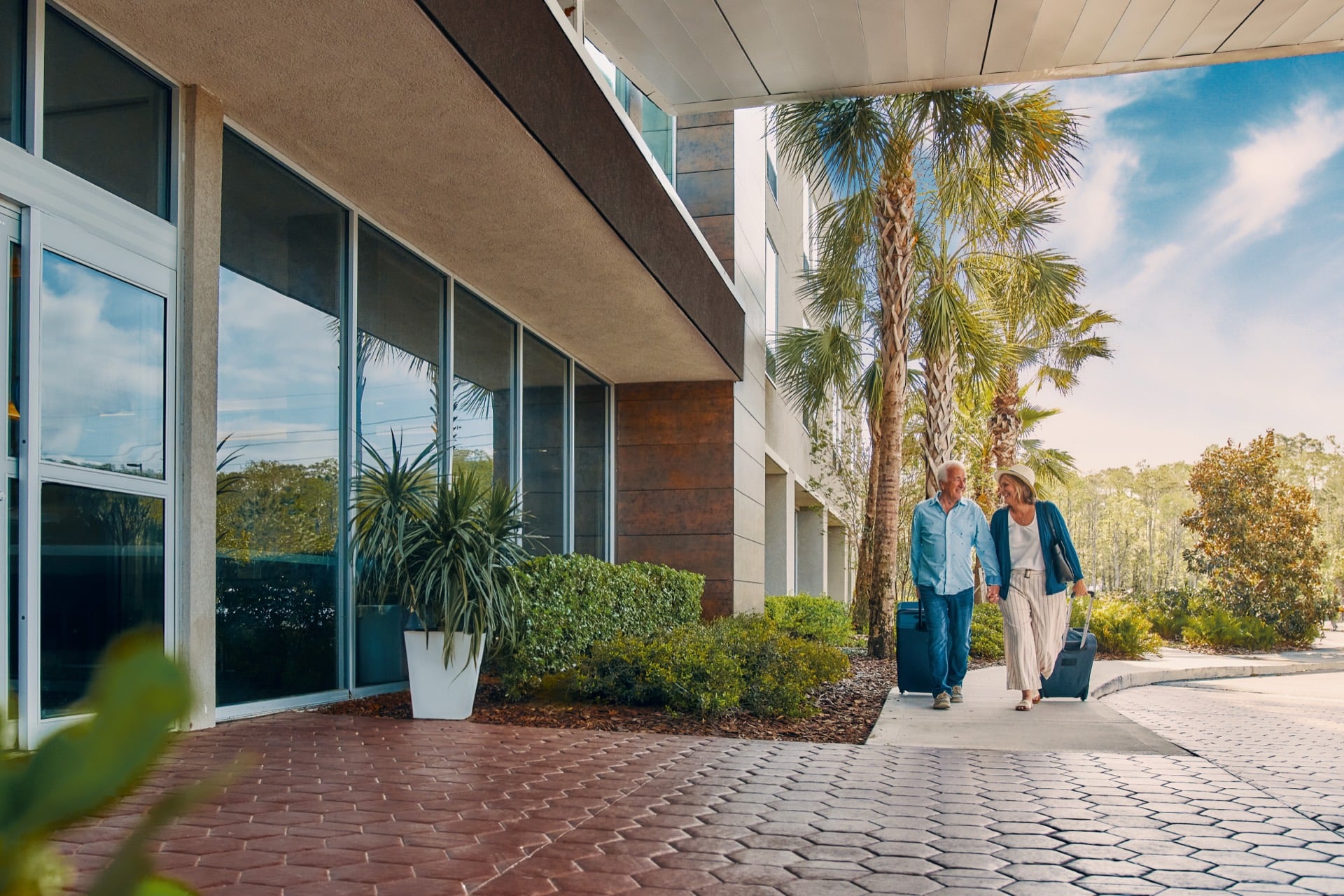 Couple walking with luggage outside a Club Wyndham resort entrance